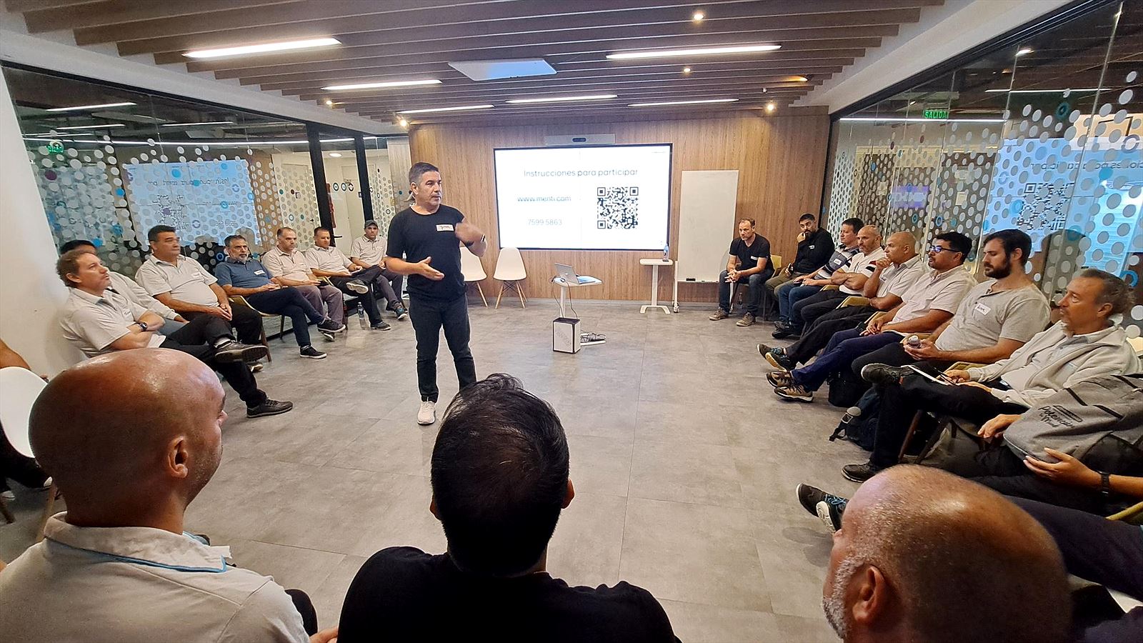 Javier Ginez coordinando un taller con un equipo sentado en ronda